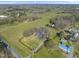 A landscape aerial view of a farmhouse estate with pond, fields, and barn at 7055 Old 421 Rd, Liberty, NC 27298
