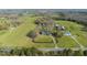 Expansive aerial view of a farmhouse estate with fields, trees, and outbuildings at 7055 Old 421 Rd, Liberty, NC 27298