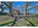 Backyard view of the house and outbuildings with a fenced yard and mature trees at 7055 Old 421 Rd, Liberty, NC 27298