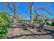 Inviting backyard features mature trees, patio furniture, and a cozy fire pit area for outdoor entertaining at 7055 Old 421 Rd, Liberty, NC 27298