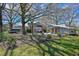 Backyard view of the house and outbuildings with a fenced yard and mature trees at 7055 Old 421 Rd, Liberty, NC 27298