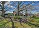 Backyard view of the house and outbuildings with a fenced yard and mature trees at 7055 Old 421 Rd, Liberty, NC 27298