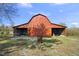 View of the red barn with an open bay door and a clear blue sky at 7055 Old 421 Rd, Liberty, NC 27298