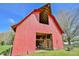Detailed view of a red barn highlighting its architectural design and open interior with wooden beams and spacious layout at 7055 Old 421 Rd, Liberty, NC 27298