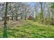 View of the property with a rustic red barn, outbuildings, and mature trees, blending charm and open space at 7055 Old 421 Rd, Liberty, NC 27298