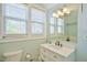 Bright bathroom with a white vanity, marble countertop, decorative mirror, and an abundance of natural light from the window at 7055 Old 421 Rd, Liberty, NC 27298