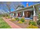 Classic brick farmhouse with a spacious front porch and landscaped walkway at 7055 Old 421 Rd, Liberty, NC 27298
