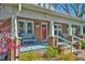 Charming red door, blue bench, and brick facade create a welcoming front porch at 7055 Old 421 Rd, Liberty, NC 27298