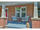 Cozy outdoor seating area with flowers and stylish decorations on a charming front porch at 7055 Old 421 Rd, Liberty, NC 27298