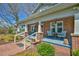 Inviting brick porch with seating, colorful flowers, and stylish decor at 7055 Old 421 Rd, Liberty, NC 27298
