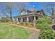 Inviting brick farmhouse showing porch with swing and landscaped front yard at 7055 Old 421 Rd, Liberty, NC 27298