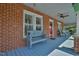 Covered porch with a blue bench and ceiling fan creates a cozy outdoor space at 7055 Old 421 Rd, Liberty, NC 27298