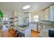 Bright kitchen featuring white cabinets, central island with stovetop, and stainless steel appliances at 7055 Old 421 Rd, Liberty, NC 27298