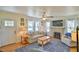 Bright living room with a brick fireplace, ceiling fan, and comfortable couch with blue accents at 7055 Old 421 Rd, Liberty, NC 27298