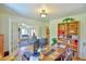 Bright office featuring a wood desk, large bookcase, and an open doorway to a cozy living room at 7055 Old 421 Rd, Liberty, NC 27298