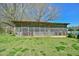Exterior view of a screened outbuilding with a rustic wooden design and surrounding green grass at 7055 Old 421 Rd, Liberty, NC 27298