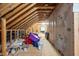 Unfinished attic featuring insulation, exposed beams, and a clutter of household items at 706 Tibumoll Ln, Fuquay Varina, NC 27526