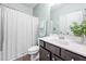 Well-lit bathroom featuring a dark vanity, coordinated accessories, and a plant that adds a touch of freshness at 706 Tibumoll Ln, Fuquay Varina, NC 27526