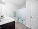 Clean bathroom with wood floor, white cabinets, and shower with leaf-patterned curtain at 706 Tibumoll Ln, Fuquay Varina, NC 27526