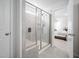 Modern bathroom featuring a glass-enclosed shower with a built-in seat, complemented by neutral tile and bright natural light at 706 Tibumoll Ln, Fuquay Varina, NC 27526