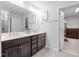 Bathroom showcasing a double sink vanity, stylish fixtures, and a view into a well-organized walk-in closet at 706 Tibumoll Ln, Fuquay Varina, NC 27526