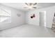 A bright bedroom with an open doorway, a ceiling fan, and neutral decor at 706 Tibumoll Ln, Fuquay Varina, NC 27526