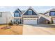 Charming two-story home with a two car garage, blue siding, stone accents and well-manicured lawn at 706 Tibumoll Ln, Fuquay Varina, NC 27526