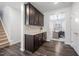 Hallway with dark wood cabinets and light granite countertops, leading to a home office and staircase at 706 Tibumoll Ln, Fuquay Varina, NC 27526