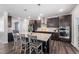 Gourmet kitchen with dark wood cabinetry, granite countertops, stainless steel appliances, and a large center island at 706 Tibumoll Ln, Fuquay Varina, NC 27526