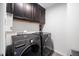 Convenient laundry room with modern gray LG washer and dryer set, and dark cabinets offering a functional and sleek space at 706 Tibumoll Ln, Fuquay Varina, NC 27526