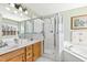Bathroom featuring a bathtub, a glass shower, a double sink, and updated fixtures at 712 Ledgerock Rd, Wake Forest, NC 27587