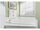 Bathroom with a white corner bathtub and a window with natural light at 712 Ledgerock Rd, Wake Forest, NC 27587
