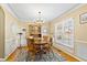 Traditional dining room with chandelier, wooden table, and beautiful natural light from large window at 712 Ledgerock Rd, Wake Forest, NC 27587