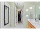 Hallway with white doors, green walls, white tile floor, and a view of a closet at 712 Ledgerock Rd, Wake Forest, NC 27587