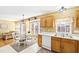 Bright eat-in kitchen featuring white appliances, wood cabinets, and a dining table at 712 Ledgerock Rd, Wake Forest, NC 27587