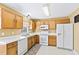 Well-lit kitchen featuring white appliances and wooden cabinets at 712 Ledgerock Rd, Wake Forest, NC 27587