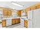 Kitchen with oak cabinets, white appliances, white countertops and double sink at 712 Ledgerock Rd, Wake Forest, NC 27587