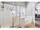 Bright bathroom featuring a glass enclosed shower and soaking tub with plantation shutters over the window at 804 Chancellors Ridge Dr, Durham, NC 27713