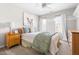 Light bedroom with a patterned bedspread, two windows with white curtains, and a light gray carpet at 804 Chancellors Ridge Dr, Durham, NC 27713