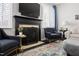 Close up of fireplace with dark mantel, blue chairs, and light grey walls at 804 Chancellors Ridge Dr, Durham, NC 27713
