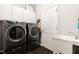 Efficient laundry room with front-loading washer and dryer, storage cabinets, and utility sink at 804 Chancellors Ridge Dr, Durham, NC 27713
