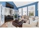 Bright living room with a blue accent wall, large windows, and an open floor plan with a view to the kitchen at 804 Chancellors Ridge Dr, Durham, NC 27713