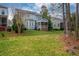 Expansive backyard featuring a lush lawn, mature trees, and a screened porch, perfect for outdoor enjoyment at 812 Long Meadows Rd, Chapel Hill, NC 27516