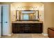 Bathroom features a double vanity with granite countertops, dark wood cabinets, and a large framed mirror at 812 Long Meadows Rd, Chapel Hill, NC 27516