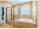 Bright bathroom featuring a soaking tub, separate glass-enclosed shower, and tile flooring at 812 Long Meadows Rd, Chapel Hill, NC 27516