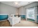 Bright bedroom with a ceiling fan, a blue accent wall and a window with translucent curtains at 812 Long Meadows Rd, Chapel Hill, NC 27516