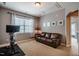 Exercise room with a stationary bike, a window with decorative curtains and a brown leather couch at 812 Long Meadows Rd, Chapel Hill, NC 27516