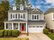 Charming gray two-story home with a welcoming red door, white garage doors and a manicured front yard at 812 Long Meadows Rd, Chapel Hill, NC 27516