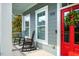 Cozy front porch features classic rocking chairs, framed by white columns and a vibrant red door at 812 Long Meadows Rd, Chapel Hill, NC 27516