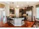 Updated kitchen featuring dark wood cabinets, stainless appliances, and bar seating at 812 Long Meadows Rd, Chapel Hill, NC 27516